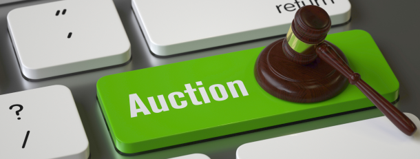 Keyboard with a green auction button with a gavel pressing it